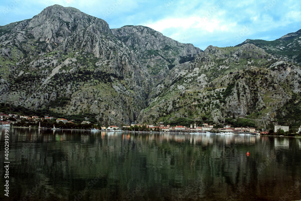 Bay of Kotor, also known as Kotorska Boka, during a quiet summer evening with mountains reflecting in the waters of the Adriatic sea.