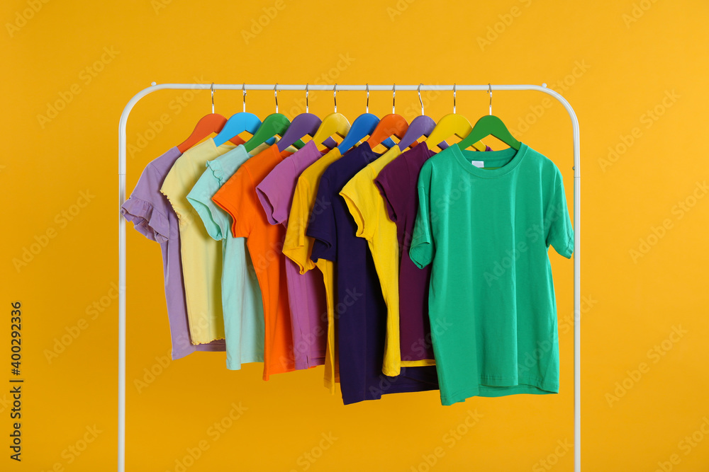 Obraz premium Rack with stylish children clothes on yellow background