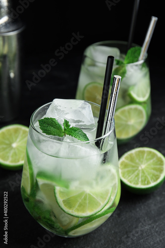 Delicious mojito and ingredients on black table