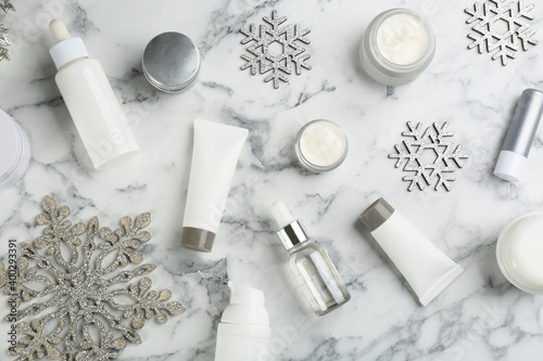 Flat lay composition with different cosmetic products on white marble table. Winter care