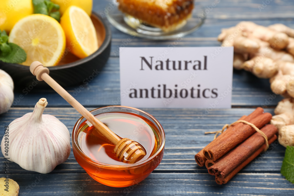 Different fresh products and card with phrase Natural Antibiotic on blue wooden table Different fresh products and card with phrase Natural Antibiotic on blue wooden table
