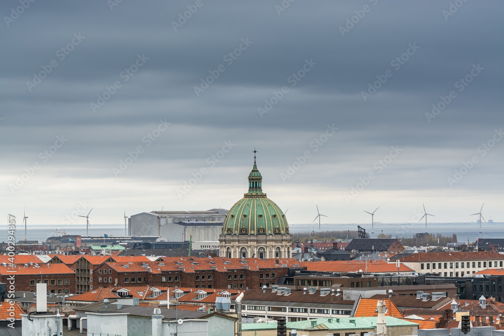 Aerial view of Copenhagen City from the The Round Tower (Rundetaarn) in rainy misty day with cloudy sky and building of red roofs and Frederik's Church (Frederiks Kirke) and factories