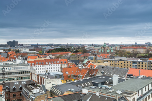Aerial view of old downtown of Copenhagen City from the The Round Tower (Rundetaarn) in rainy misty day with cloudy sky with red house roofs and churches