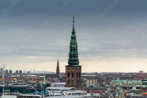 Aerial view of Copenhagen City from the The Round Tower (Rundetaarn) in rainy misty day with cloudy sky and Saint Nikolas church bell tower, Now is Nikolaj Copenhagen Contemporary Art Center