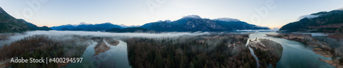 Aerial Panoramic Canadian Nature Landscape with mountains in background. Sunny Sunrise Sky. Taken in Squamish, North of Vancouver, British Columbia, Canada.