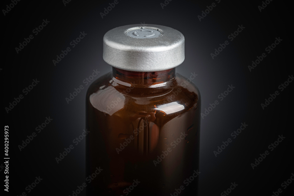 Macro Image Of Amber Vaccine Vial In Black Background