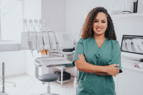 Young blond Caucasian female opening her mouth while African-American ethnic dentist in white latex gloves check condition of her teeth focus on dentist