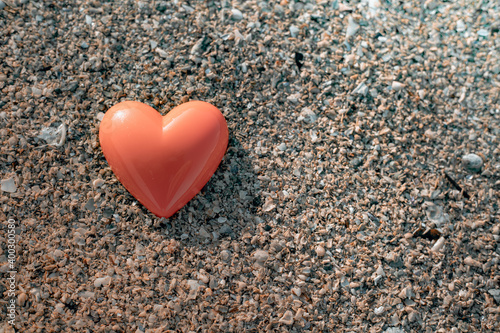 Orange heart on sea beach and sand background, love relax concept.
