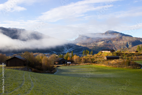 Beautiful mountain landscape covered with fog in autumn, path to the village,norwegian valley, Norway Buskerud Hemsedal,print for postcard,wallpaper,cover design,poster ,calendar,morning mist photo