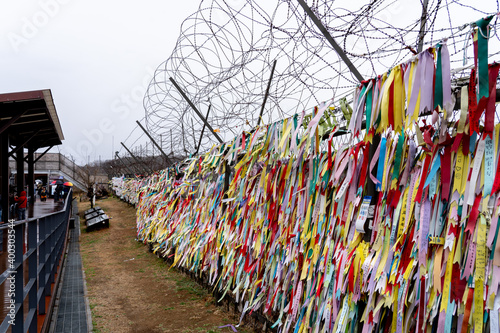 Paju, South Korea - April 10, 2019: Prayer ribbons tied on the fence at Imjingak Park near DMZ in Paju, South Korea. South Koreans tie ribbons with messages for their family members in the North. photo
