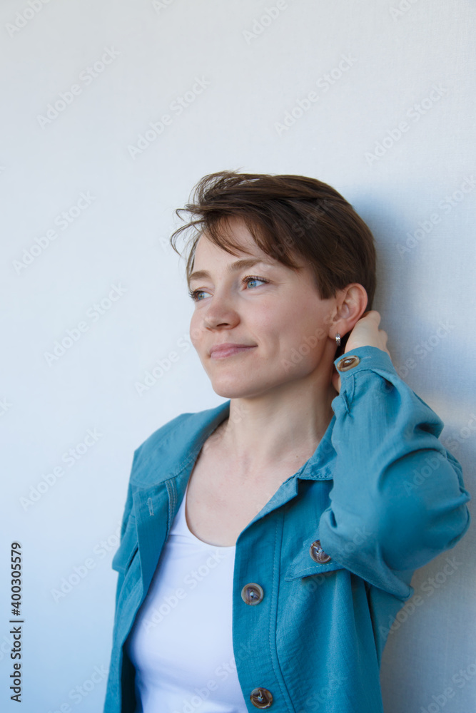 Portrait of beautiful young happy smiling woman with short hair in blue clothing,.white background background Portrait of beautiful young happy smiling woman with short hair in blue clothing,.white background background