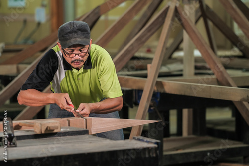 Carpenter making Tunjuk Langit or one of the roof structures. Hip Roof