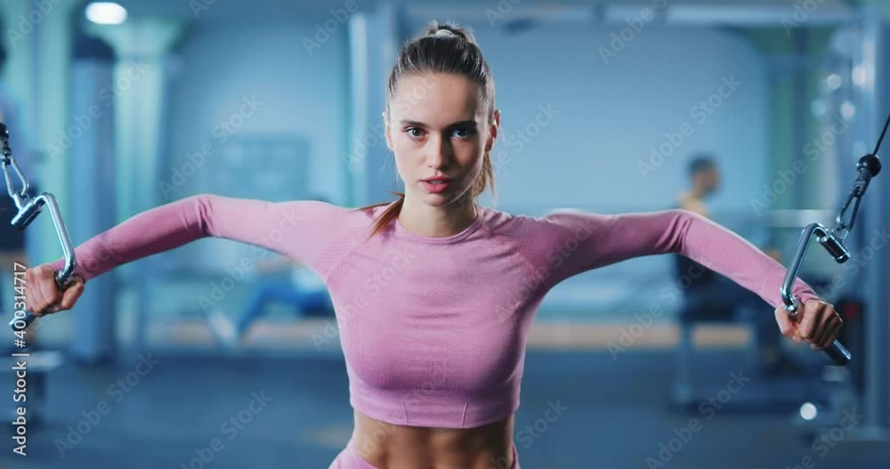 Beautiful fit young female athlete wearing pink sportswear looking sexy doing stretching weightlifting arm exercises bodybuilding at the gym. Sportswoman lifestyle. Strength. Beautiful fit young female athlete wearing pink sportswear looking sexy doing stretching weightlifting arm exercises bodybuilding at the gym. Sportswoman lifestyle. Strength.