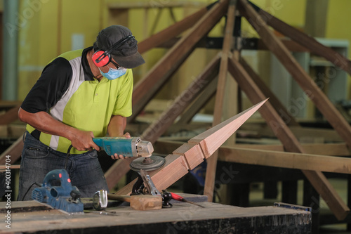 Carpenter making Tunjuk Langit or one of the roof structures. Hip Roof © azami