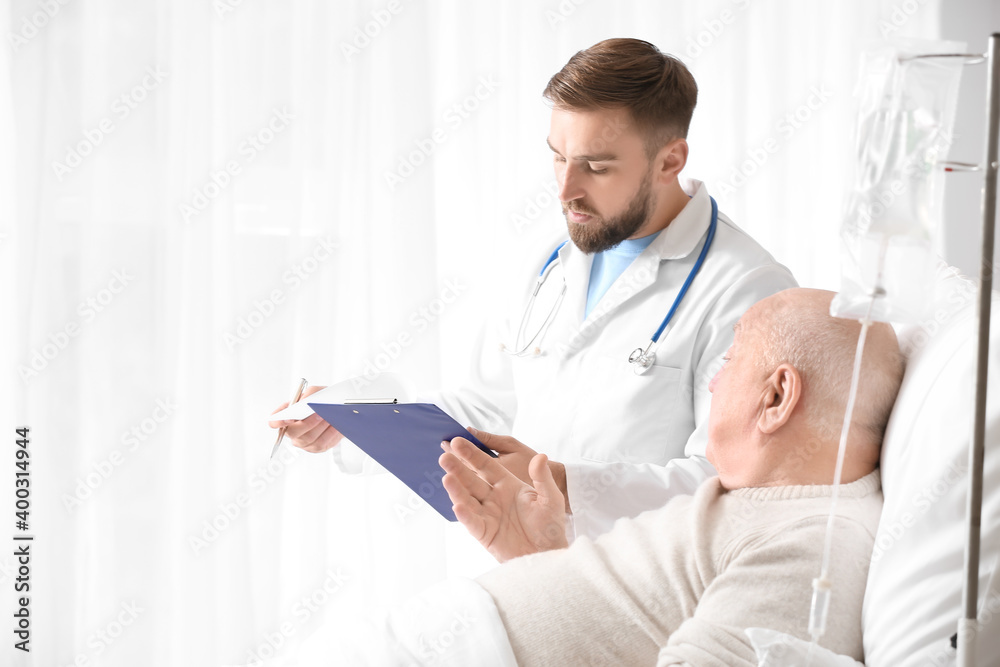 Doctor and senior man undergoing course of chemotherapy in clinic. Prostate cancer awareness concept Doctor and senior man undergoing course of chemotherapy in clinic. Prostate cancer awareness concept