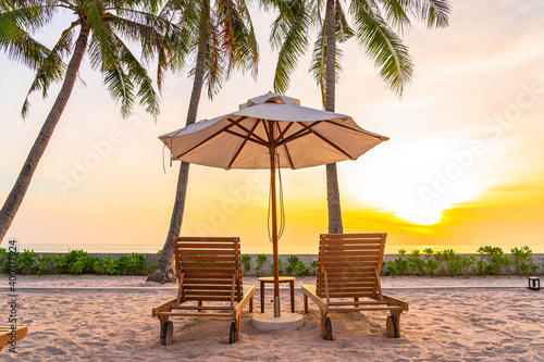 Umbrella and deck chair on tropical beach sea ocean at sunset or sunrise time