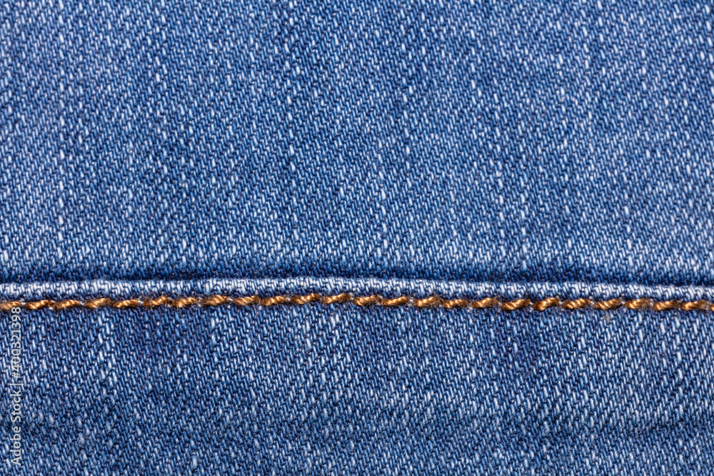 Close-up shot of blue jeans fabric with a seam. Copy space. Top view. Clothing store and shopping concept Close-up shot of blue jeans fabric with a seam. Copy space. Top view. Clothing store and shopping concept