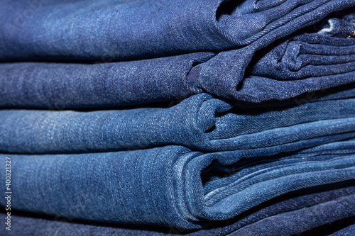 Closeup shot of stack of folded blue jeans in fashion store. Shopping and clothing industry concepts