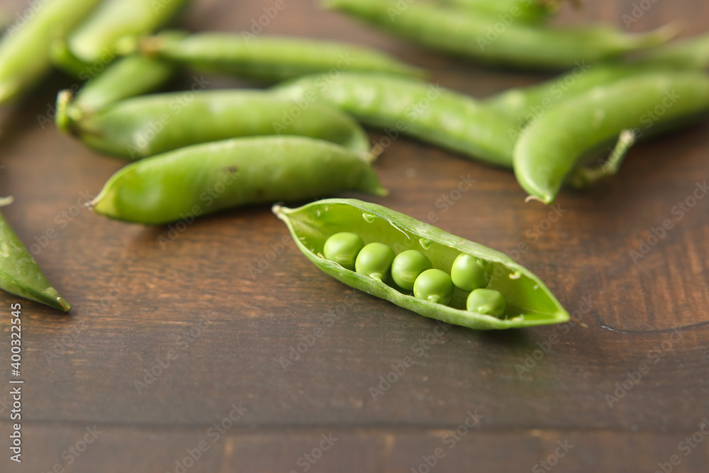Fresh green peas isolated on wooden table Fresh green peas isolated on wooden table