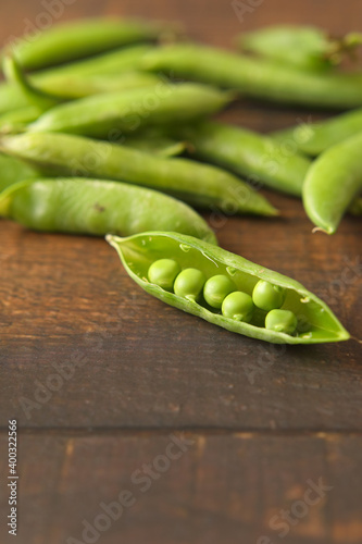 Fresh green peas isolated on wooden table 