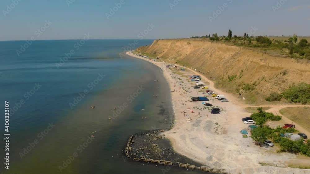 Travelers resting on abandoned wild sea beach in shore camping near cliff. Active and tourist lifestyle concept