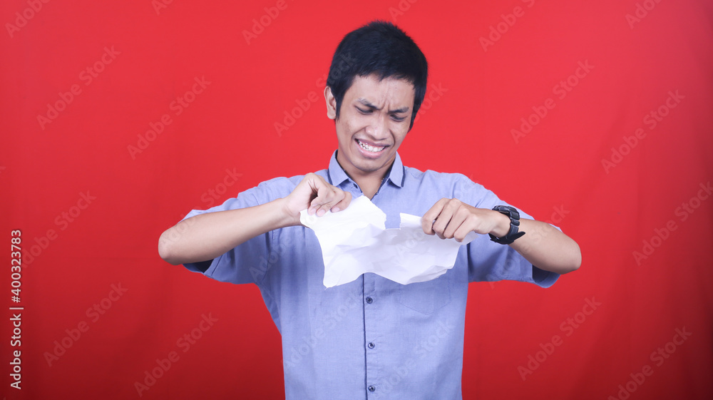 Asian man stress tear the paper isolated red background Asian man stress tear the paper isolated red background