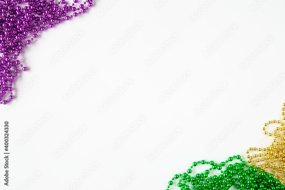 Mardi gras background, border on white with purple gold green beads and copy space - obrazy, fototapety, plakaty 
