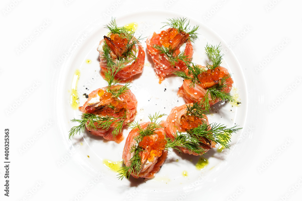 roll with caviar, salmon and fried shrimps, decorated with dill on a white plate. appetizer with seafood. Isolated, white background, close-up roll with caviar, salmon and fried shrimps, decorated with dill on a white plate. appetizer with seafood. Isolated, white background, close-up