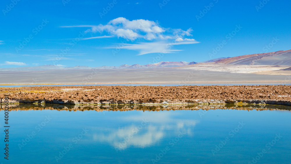 Obraz premium White clouds on blue sky mirroring in a lake. Puna highlands, Argentina