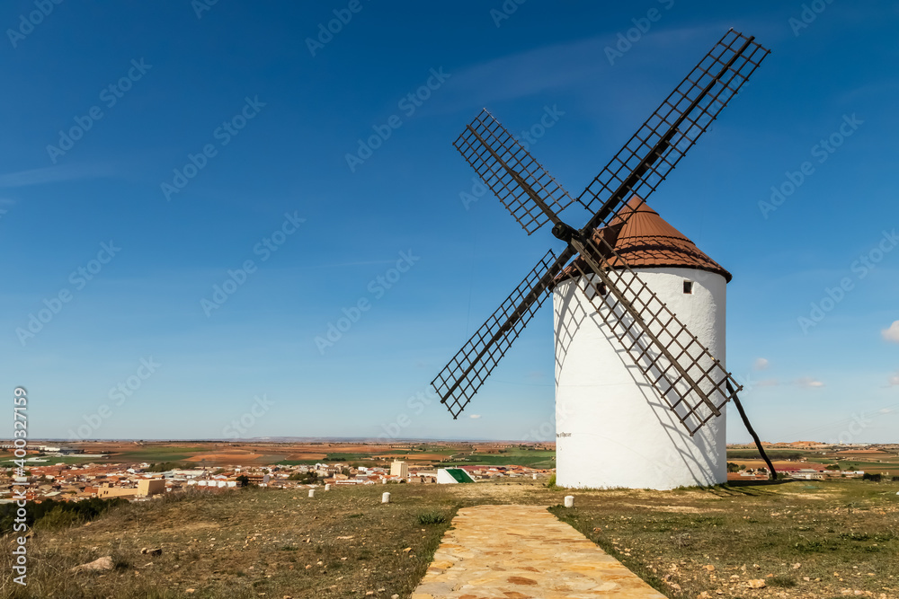 Ancient stone windmills in La Mancha. Blue sky with clouds.
