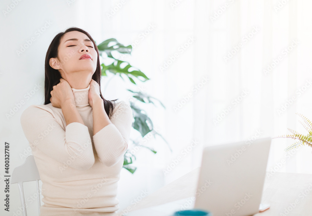 young woman with neck pain and massaging neck while working in office at home young woman with neck pain and massaging neck while working in office at home