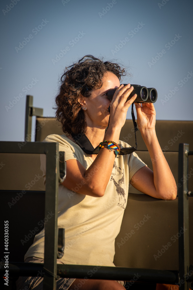 Close-up of brunette using binoculars in jeep Close-up of brunette using binoculars in jeep