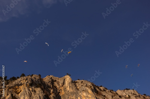 seven paraglider on blue sky with a rocky mountains and a skywalk photo