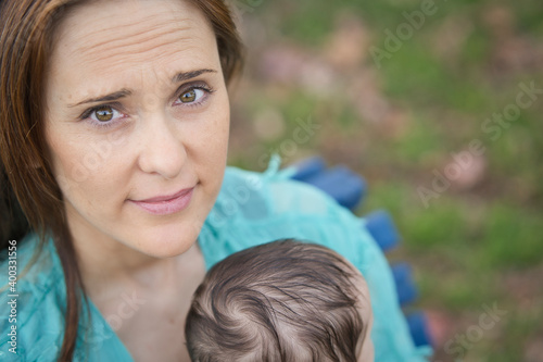 portrait of beautiful woman with her baby in a park. motherhood concept