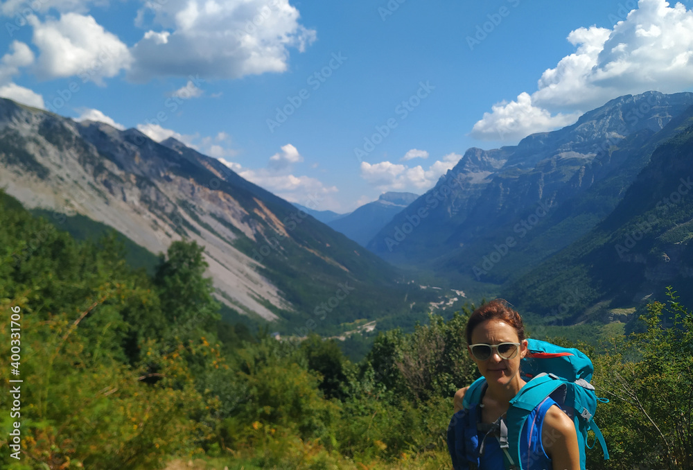 beautiful woman in the mountains with sunglasses in summer enjoying a sports day in the pyrenees