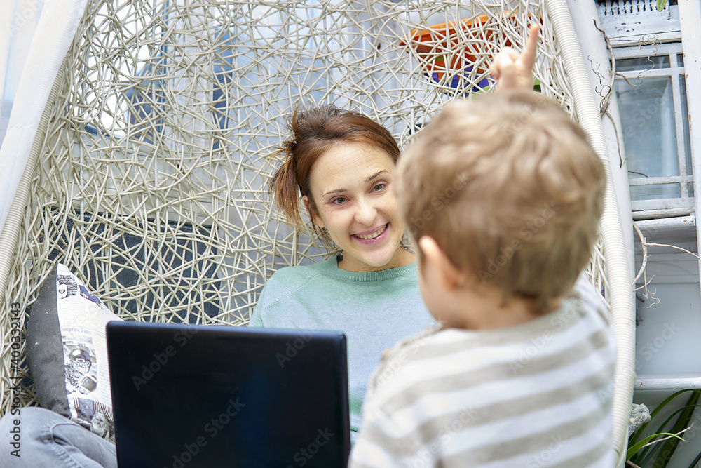woman smiling at her son at home while telecommuting. home working concept woman smiling at her son at home while telecommuting. home working concept