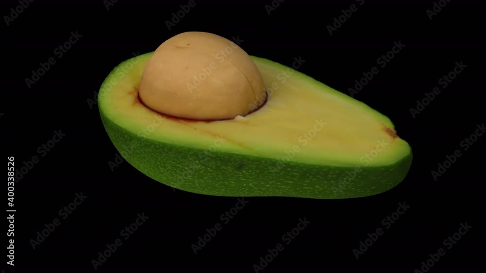 Realistic render of a rotating green Florida avocado (cut in half with pit) on transparent background (with alpha channel). The video is seamlessly looping, and the object is 3D scanned from a real av