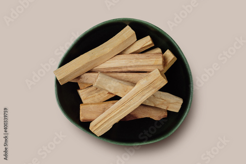 Scattered Palo Santo sticks on a black plate. Top view. Organic holy tree incense from Latin America. Color photo close-up of natural frankincense.