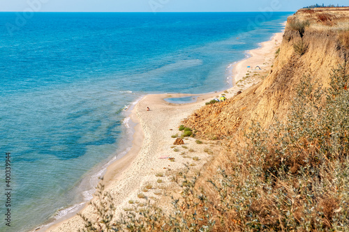 Wild sandy beach with rare people . Clay coastal cliff scenery 