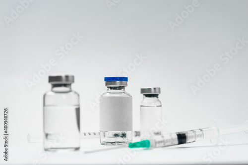 Medical treatment syringes and vaccine bottles in white environment 