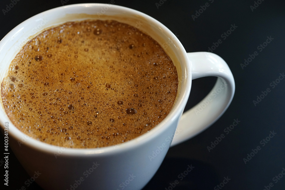 Coffee to go. Milk coffee in a cup on a black wooden table in a cafe. Coffee to go. Milk coffee in a cup on a black wooden table in a cafe.