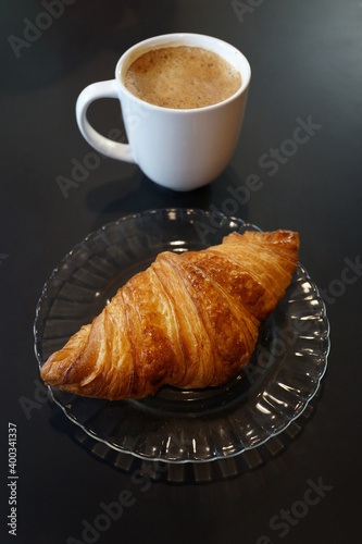Breakfast with coffee and croissants. High angle view, black background.
