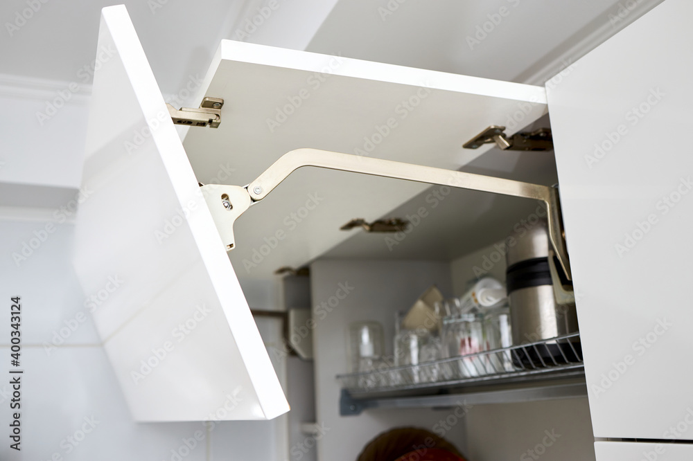 Part of contemporary kitchen interior. Opened White horizontal Kitchen with Plates and