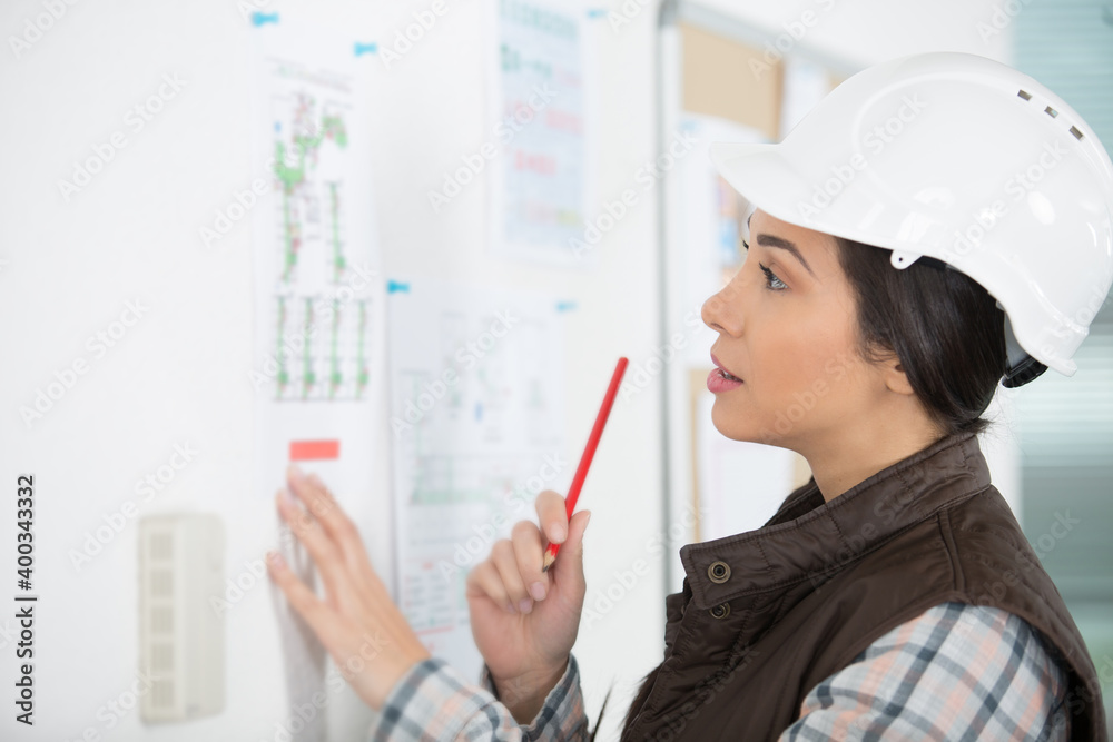 female designer in office working on architects project female designer in office working on architects project