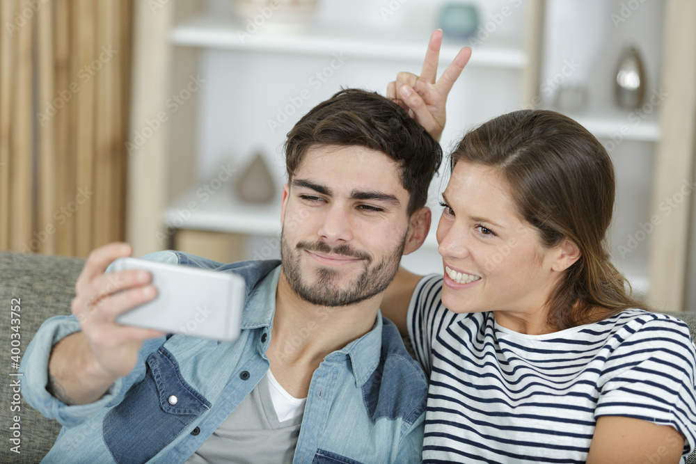 young couple together taking funny photos at home