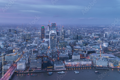 Illuminated London City skyline at dusk blue hour from above