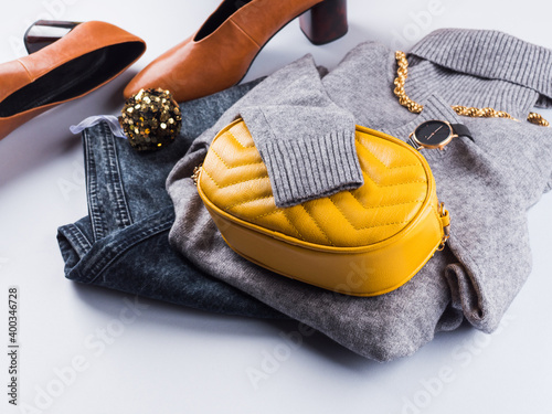 Fashion outfit with gray woolen turtle neck and illuminated yellow handbag clutch. Lady winter autumn style in trendy colors. Winter new year sale