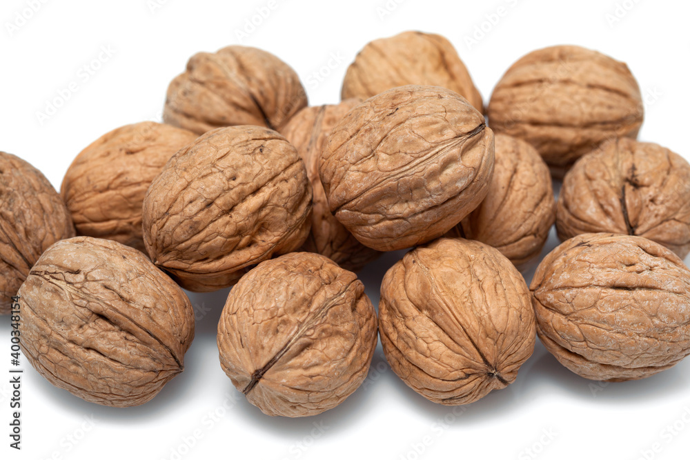 Walnuts in their shells close up on a white background Walnuts in their shells close up on a white background