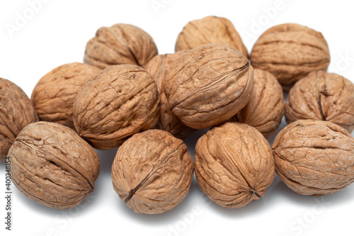 Walnuts in their shells close up on a white background