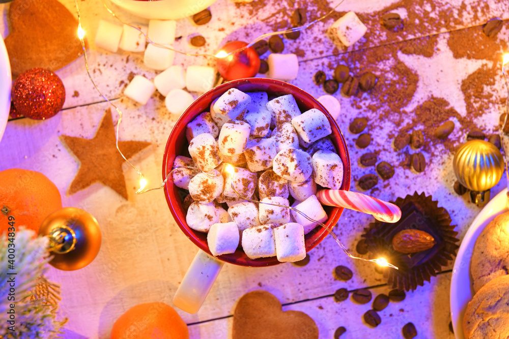 Fototapeta premium sweet food top view background for merry christmas or new year holiday decoration with night illumination - chocolate candies, tangerines, cookies, marshmallow and cocoa latte on white wood